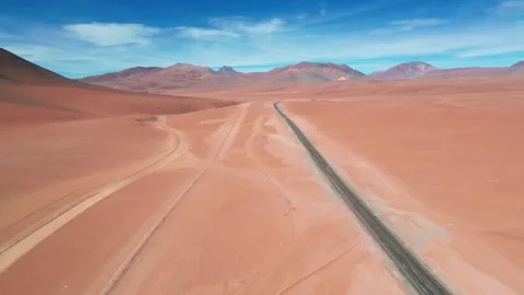Ascending drone shot rising over a straight desert highway cutting through vast Stockbeeldmateriaal 334651931