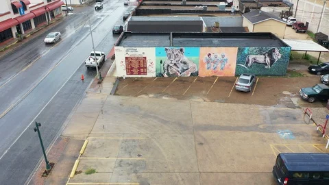 Ascending flight from building murals in light rain, downtown, La Feria, TX, USA Stock Footage 129201045