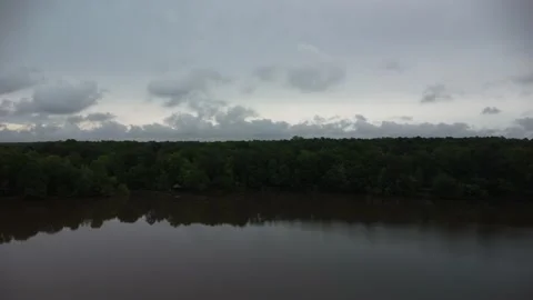 Ascending flight from lake to forest with clouds on the horizon Video stock 239938884