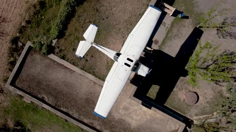 Ascending orbital top view of a display abandoned single-engine small plane in Stock Footage 297698879