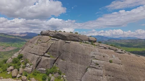 Ascending Over a Giant Monolithic Rock Revealing a Vast Green Valley Stock-Footage 341101649