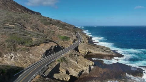 Ascending Pull Back Above Two Lane Cliffside Highway On Sunlit Hawaii Coast Stock Footage 342652309