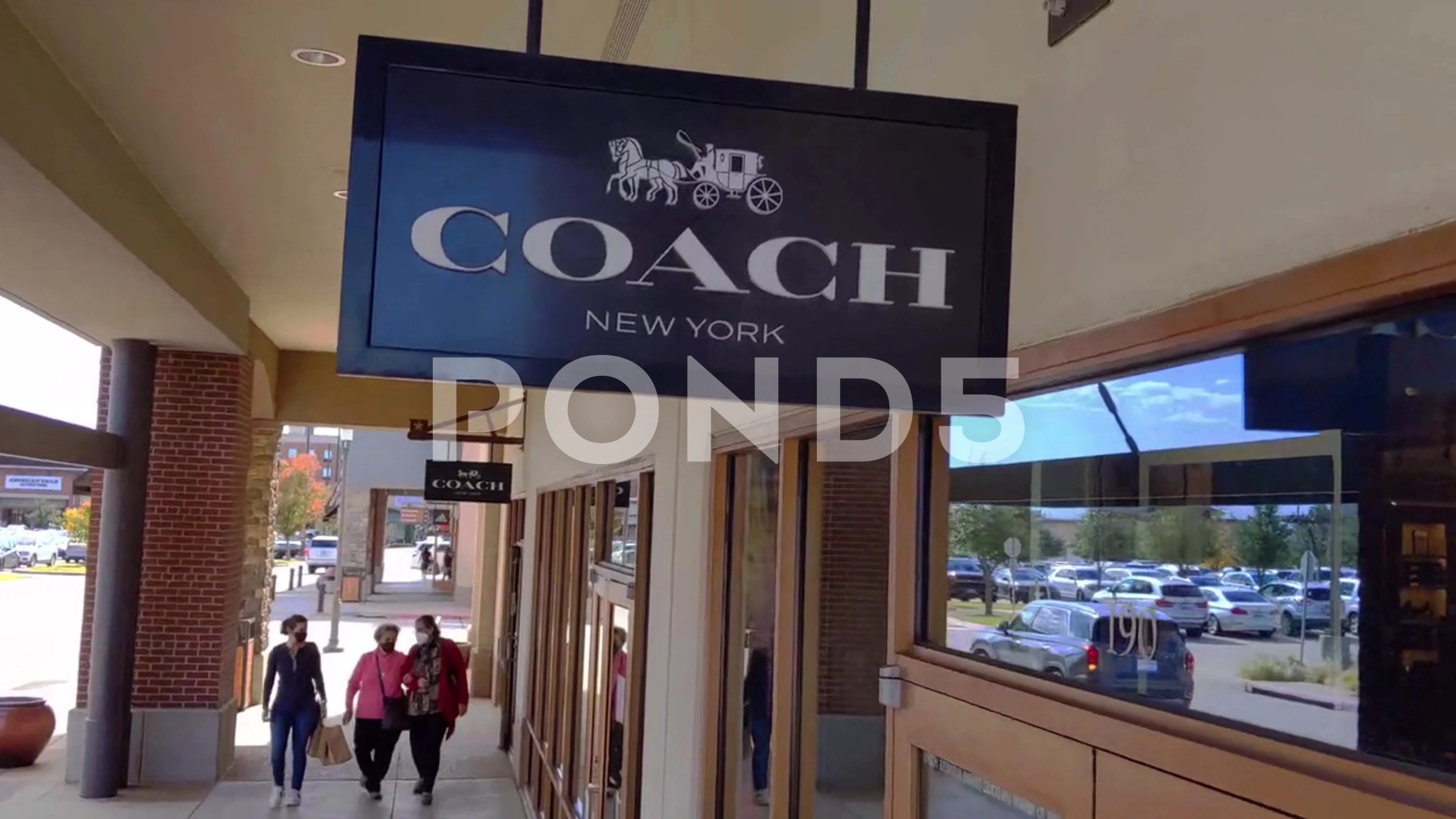 Ascending shot to close-up of Coach New York store sign at premium outlet  mall