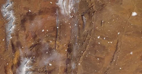 Ascending through falling snow over desert terrain in Algeria. Two versions Stock Footage 268318023