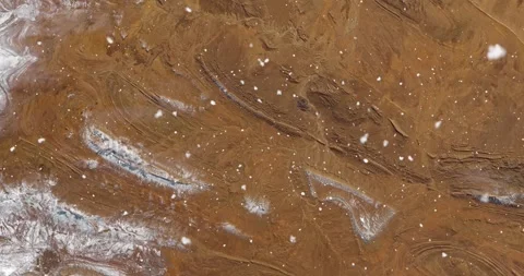 Ascending through falling snow over desert terrain in Algeria. Two versions Video stock 268318878