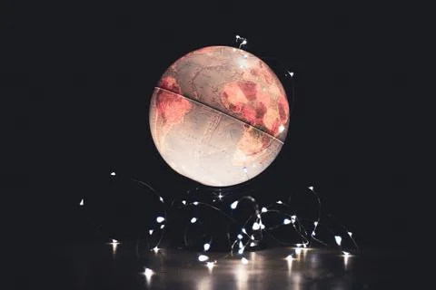 Ascenic  portrait of a light emitting globe stand on a wooden floor in a dark Foto stock
