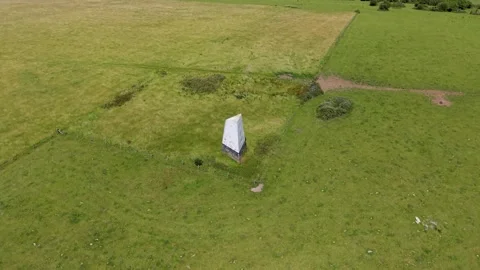Ashey Down sea mark obelisk as drone rises, locked parallax reveal over Isle of Stock Footage 339042805