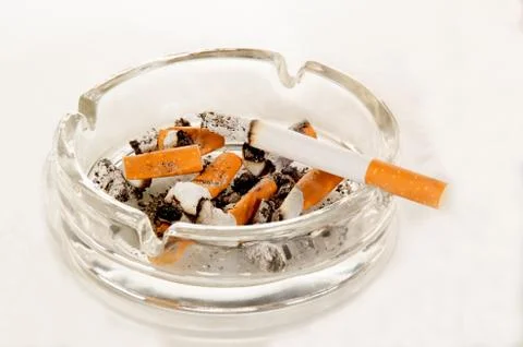 Ashtray with cigarette on bright background Stock Photos
