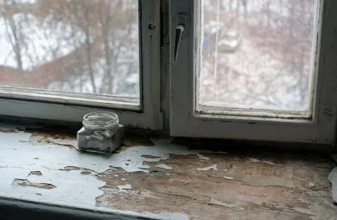 Ashtray with cigarette butts on the old window sill. Stock Photos