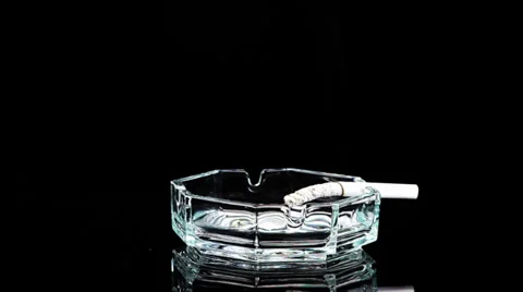Ashtray with a cigarette rotates and ash falls off Stock Footage 39720721