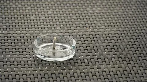 Ashtray with extinguished cigarette on the table. Bad habits concept. The end Stock Photos