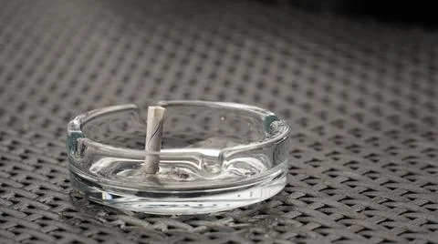 Ashtray with extinguished cigarette on the table. Bad habits concept. The end Stock Photos