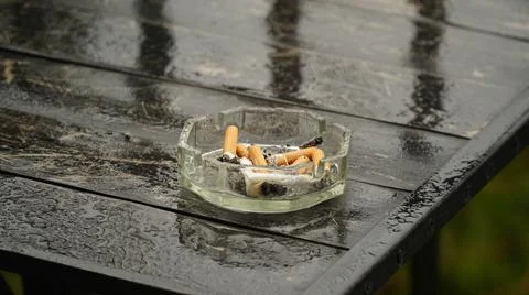 Ashtray with extinguished cigarette on the table. Bad habits concept. Ashtray Stock Photos