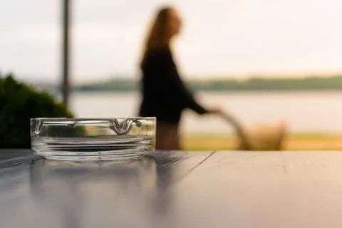 Ashtray on the table. In the background mother with a stroller in a blur Foto stock