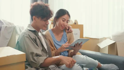 Asia couple sit on sofa couch use digital tablet online shopping at home. Stock Footage 232652550