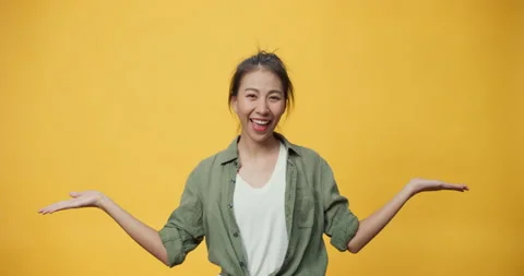 Asia lady stand over isolate yellow background open palms points away. Stock Footage 159784778