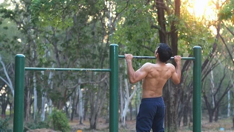 Asia Muscular man doing pull-ups on horizontal bar at playground. Stock Footage 106751955