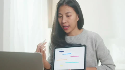 Asia woman using tablet presentation to colleagues about plan in video call. Stock Footage 135758905