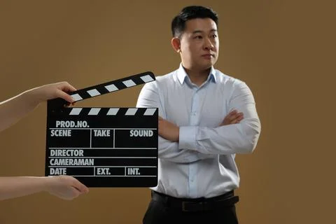 Asian actor performing while second assistant camera holding clapperboard o.. Stock Photos