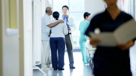 Asian American doctor male consult with patient and staff work in medical center Stock Footage