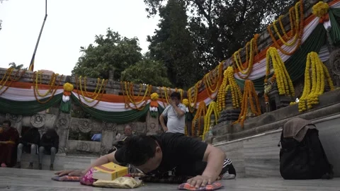 Asian and buddhist man doing prostrations in front of the Mahabodhi temple Stock Footage 230928259