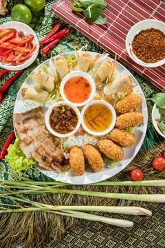 Asian appetizer platter spring roll pork shrimp sauce garnish Stock Photos