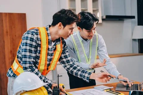 Asian architect and engineer team checking architectural house model using .. Stock Photos