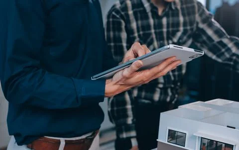 Asian architect and engineer team checking architectural house model using .. Stock Photos