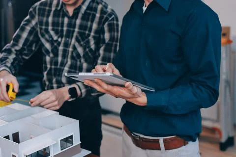 Asian architect and engineer team checking architectural house model using .. Stock Photos