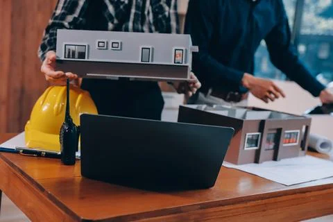 Asian architect and engineer team checking architectural house model using .. Stock Photos