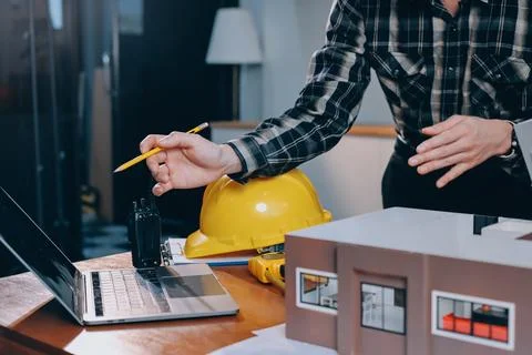 Asian architect and engineer team checking architectural house model using .. Stock Photos