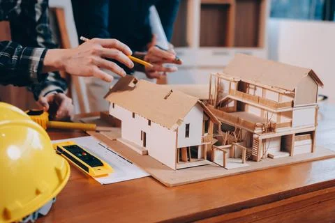 Asian architect and engineer team checking architectural house model using .. Stock Photos