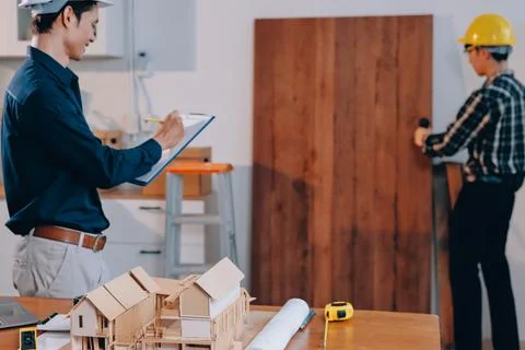 Asian architect and engineer team checking architectural house model using .. Stock Photos