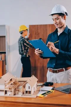 Asian architect and engineer team checking architectural house model using .. Stock Photos