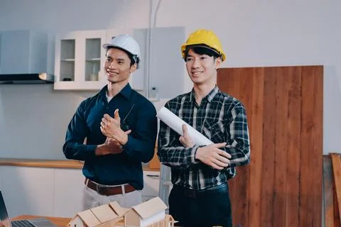Asian architect and engineer team checking architectural house model using .. Stock Photos