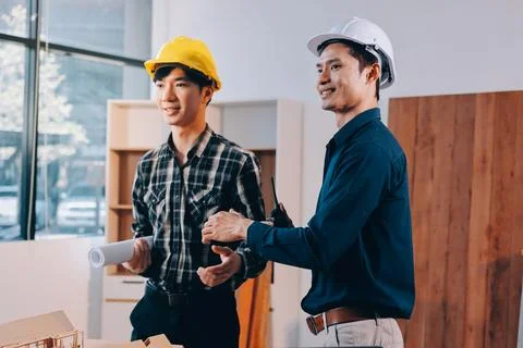 Asian architect and engineer team checking architectural house model using .. Stock Photos