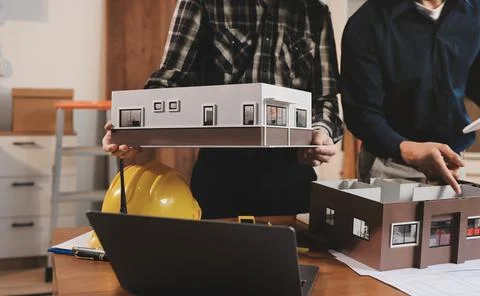 Asian architect and engineer team checking architectural house model using .. Stock Photos