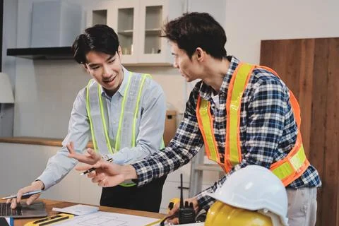 Asian architect and engineer team checking architectural house model using .. Stock Photos