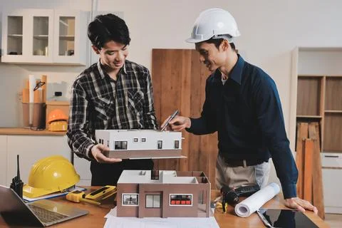 Asian architect and engineer team checking architectural house model using .. Stock Photos