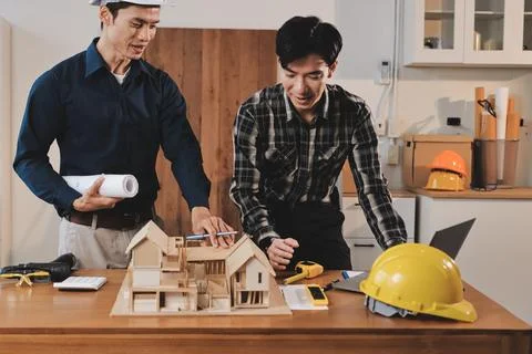 Asian architect and engineer team checking architectural house model using .. Stock Photos