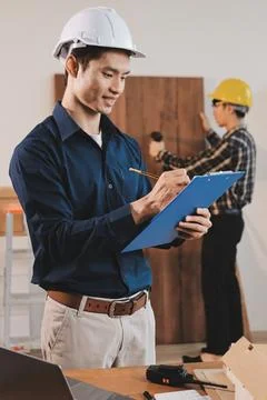 Asian architect and engineer team checking architectural house model using .. Stock Photos