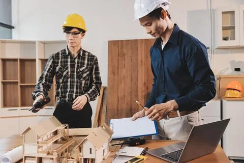 Asian architect and engineer team checking architectural house model using .. Stock Photos