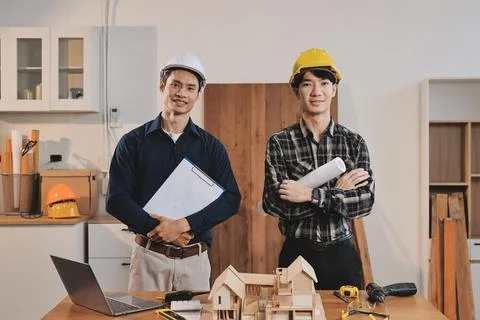 Asian architect and engineer team checking architectural house model using .. Stock Photos