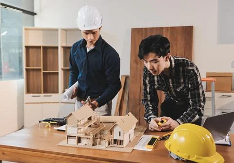 Asian architect and engineer team checking architectural house model using .. Stock Photos