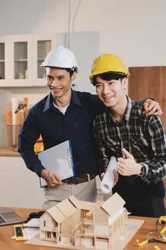 Asian architect and engineer team checking architectural house model using .. Stock Photos