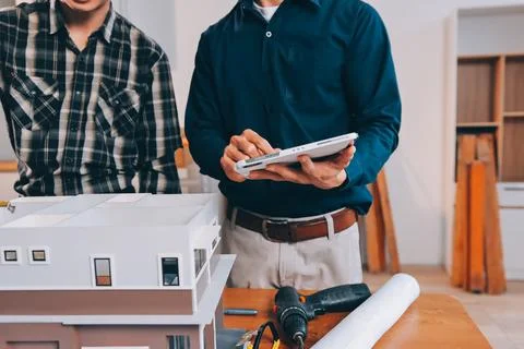 Asian architect and engineer team checking architectural house model using .. Stock Photos
