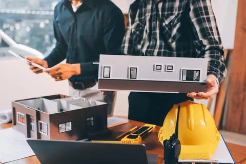 Asian architect and engineer team checking architectural house model using .. Stock Photos