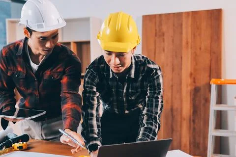Asian architect and engineer team checking architectural house model using .. Stock Photos