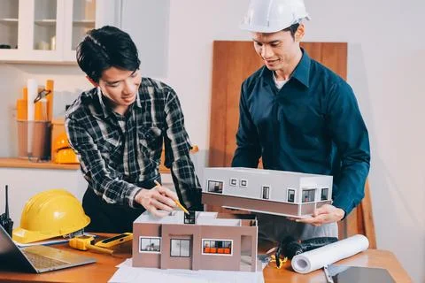 Asian architect and engineer team checking architectural house model using .. Stock Photos