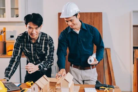 Asian architect and engineer team checking architectural house model using .. Stock Photos